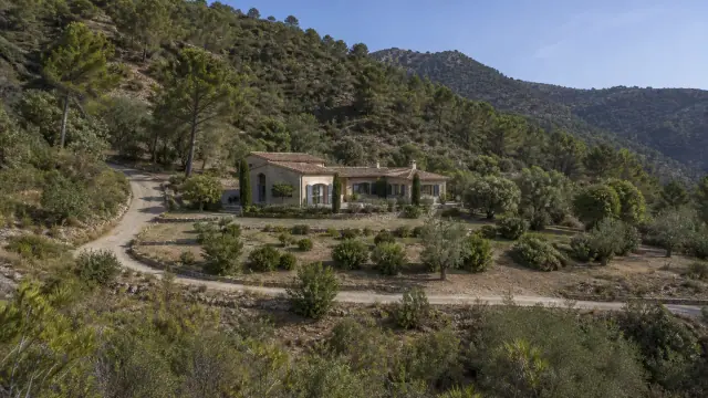 Villa en pierre entourée de végétation méditerranéenne entretenue sur une colline boisée