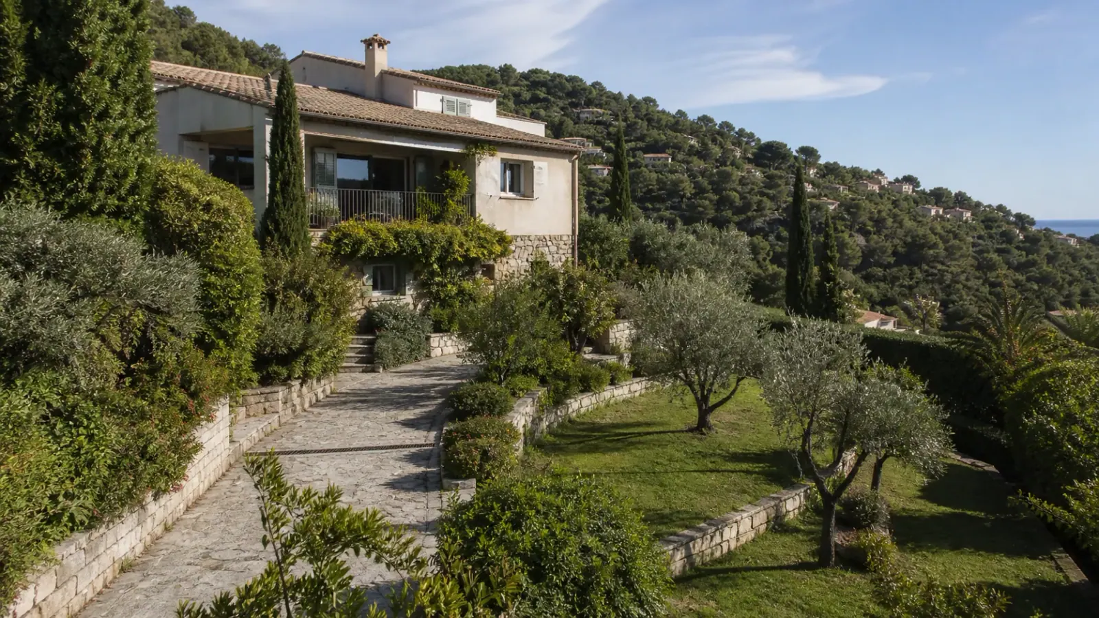Villa méditerranéenne sur un terrain en restanques avec végétation et mer au loin